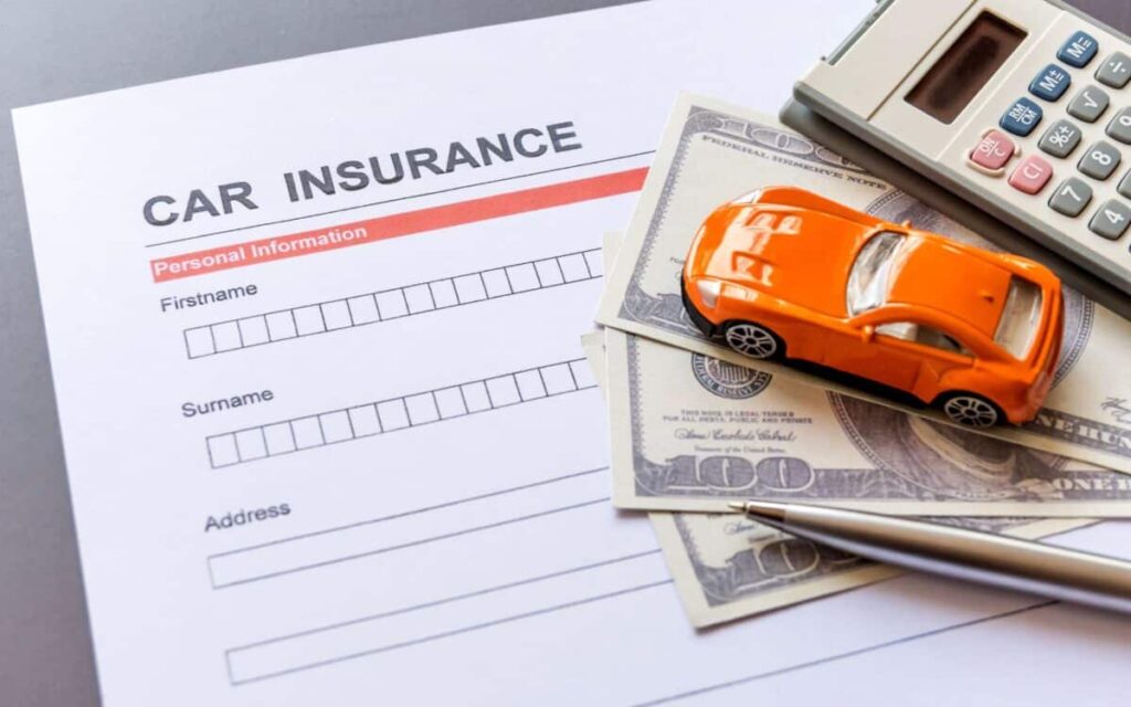 A young driver sitting in a car with a folder labeled “Car Insurance.